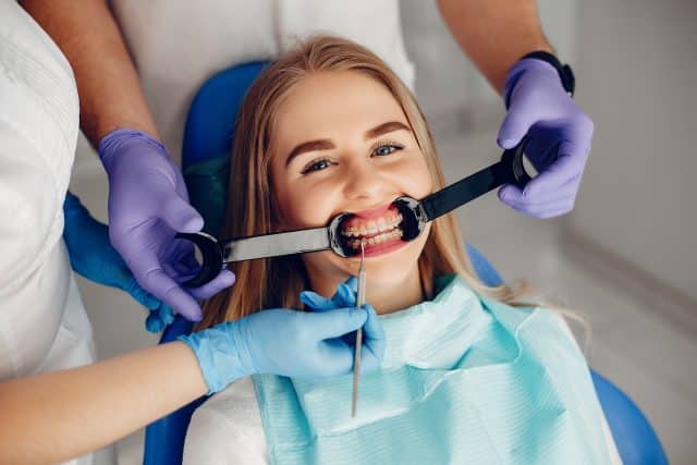 Beautiful girl sitting in the dentist's office Beautiful lady in the dentist's office. Woman in a uniform